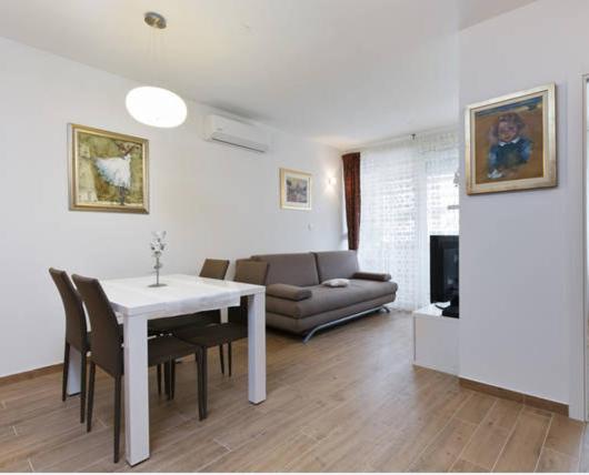 a living room with a table and chairs and a couch at Apartment Luce in Split