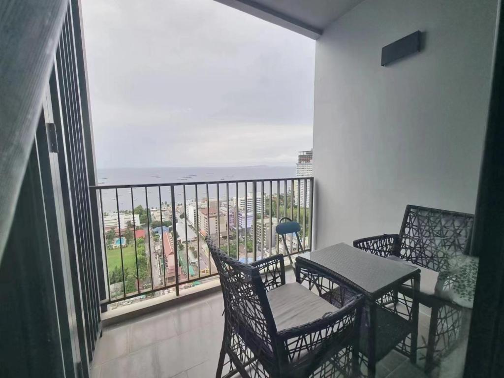 a balcony with a table and chairs and a view of the ocean at The Base海景网红顶层无边泳池 双卧室套房 in Pattaya Central