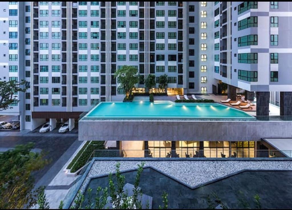 a swimming pool in front of a large building at The Base海景网红顶层无边泳池 双卧室套房 in Pattaya Central