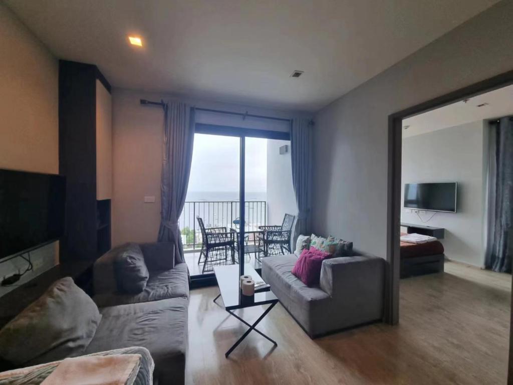 a living room with a couch and a table with a view at The Base海景网红顶层无边泳池 双卧室套房 in Pattaya Central