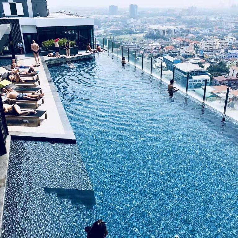 a pool on top of a building with people in it at The Base海景网红顶层无边泳池 双卧室套房 in Pattaya Central