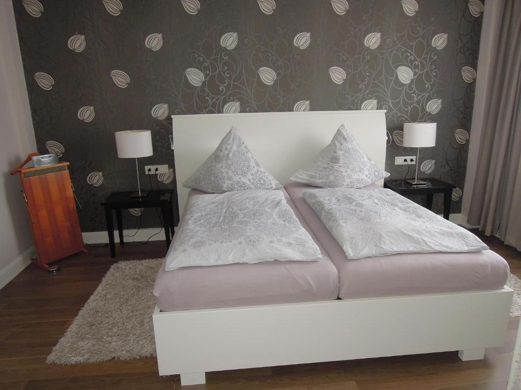 a white bed with pillows on it in a bedroom at Ferienwohnung Ein Zuhause auf Zeit in Lübeck
