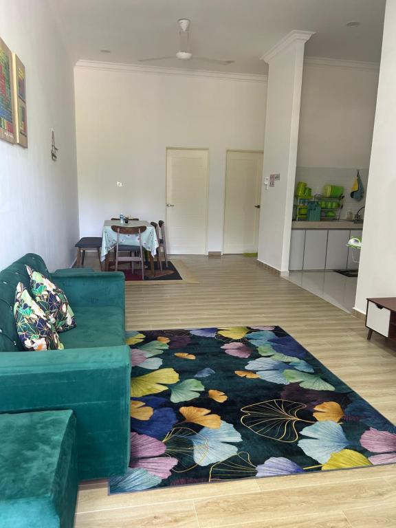 a living room with a blue couch and a rug at Ct Wani Homestay in Wakaf Baharu