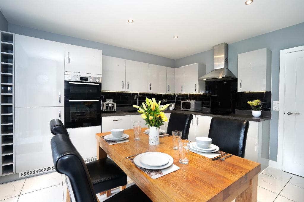 a kitchen with a wooden table and black and white appliances at Whitmore in Colchester