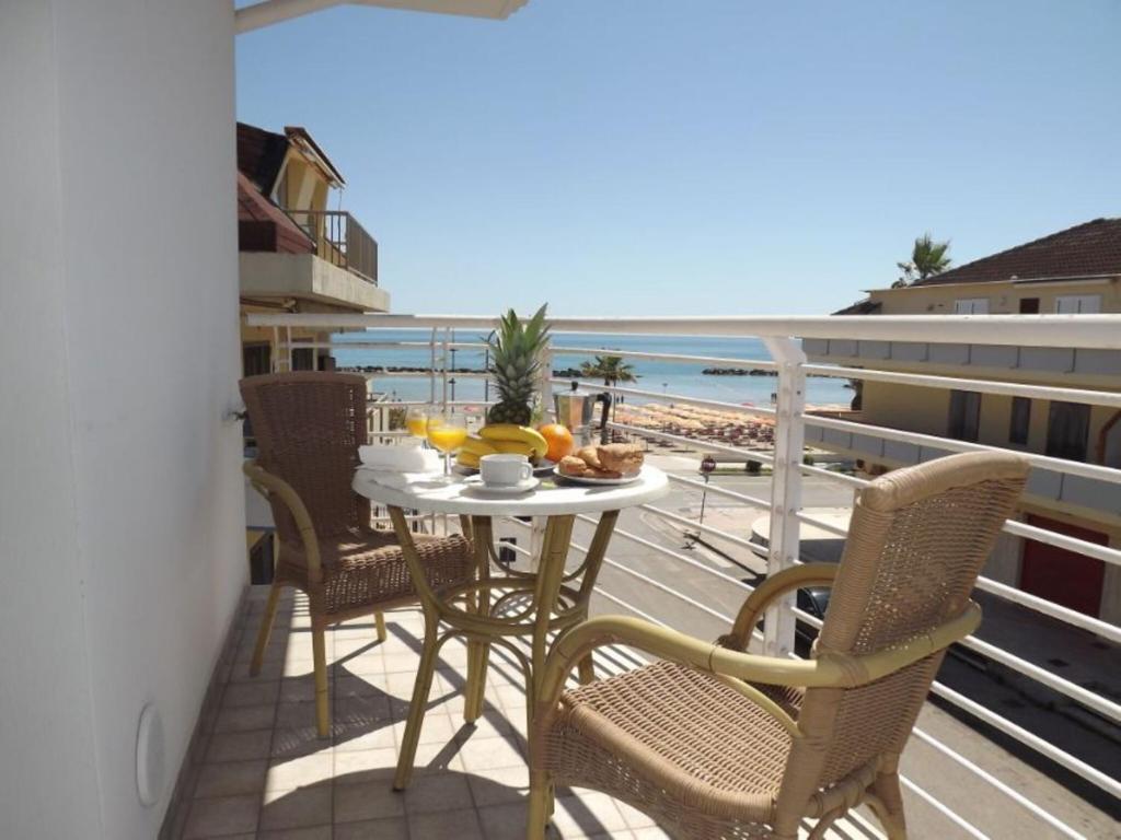a table and chairs on a balcony with a view of the beach at Residence Near The Sea - Abruzzo in Martinsicuro