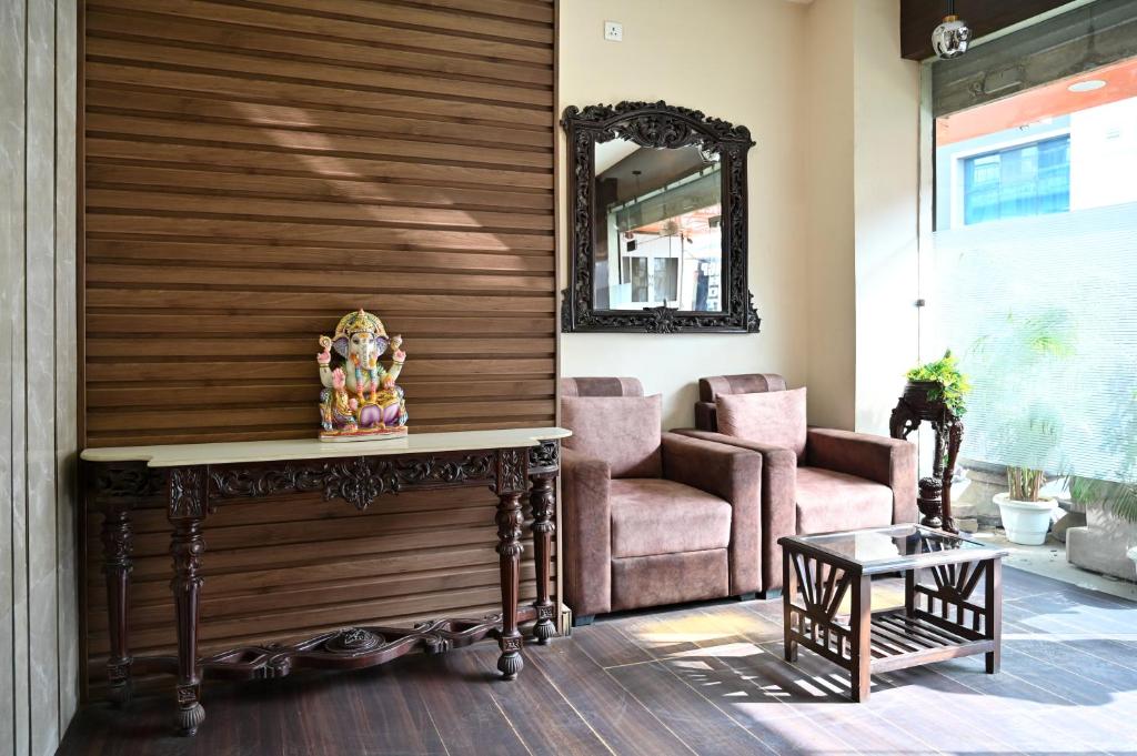 a living room with a table and a chair and a mirror at Hotel Hari Gopal in Varanasi