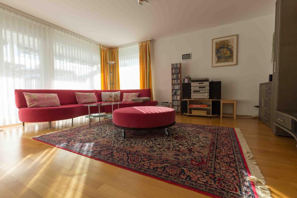 a living room with a red couch and a rug at Sunnagarta in Davos