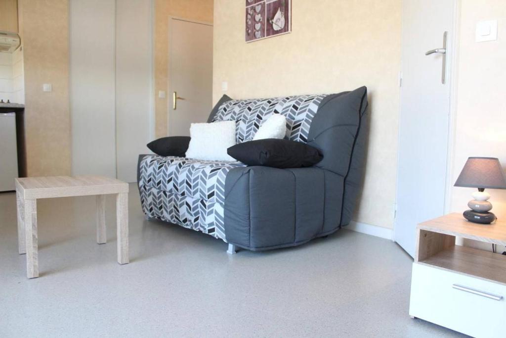 un salon avec un canapé bleu avec des oreillers dans l'établissement Appt Studio cabine LA ROCHELLE - LR040-105, à La Rochelle