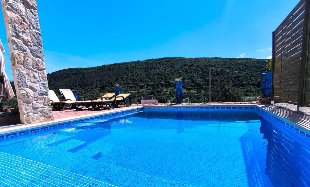 a large swimming pool with a mountain in the background at Casa-Diospiro-villa-for-4P-baby-with-private-pool in São Bartolomeu de Messines