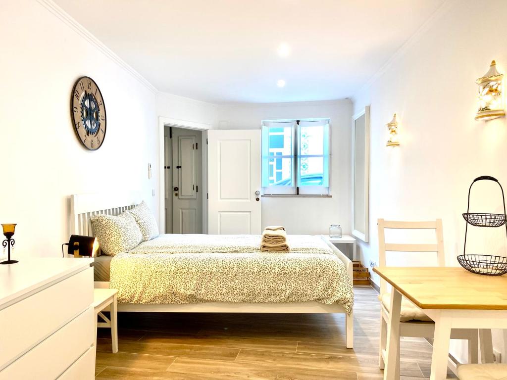 a white bedroom with a bed and a table at Casa da Trindade Olhão - Boutique Collection in Olhão