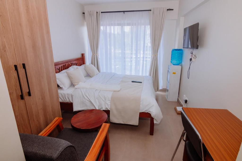 a small bedroom with a bed and a window at Miiza Realtors in Nairobi