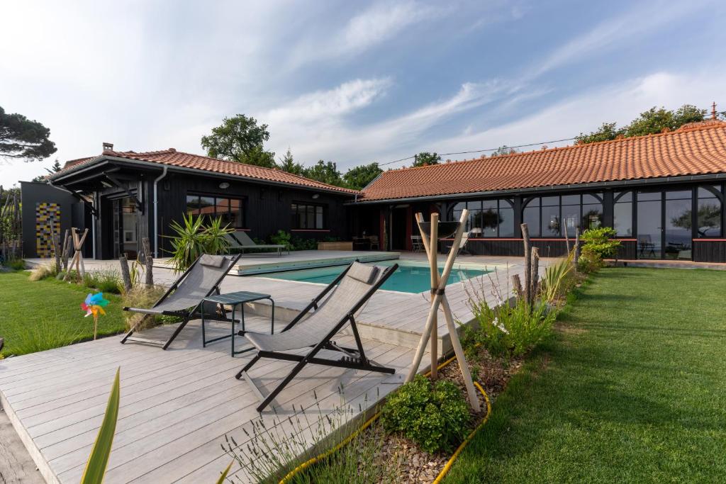 a patio with two chairs and a swimming pool at Demeure d'exception vue mer in Andernos-les-Bains