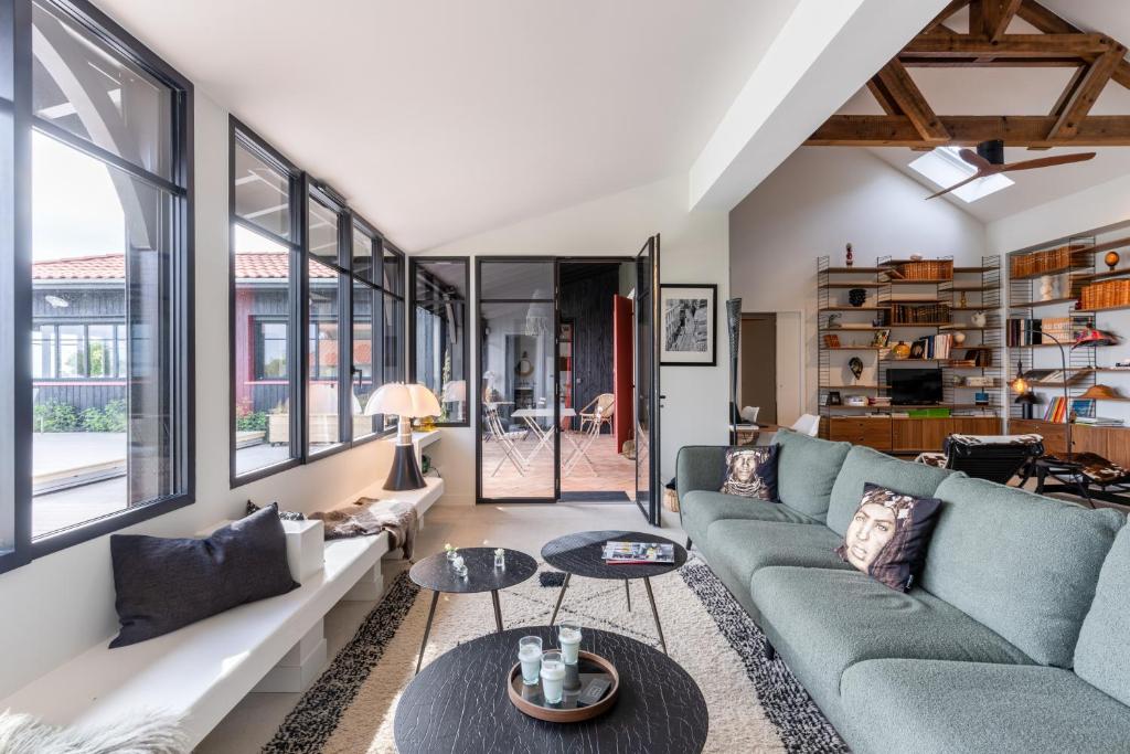 a living room with a couch and a table at Demeure d'exception vue mer in Andernos-les-Bains