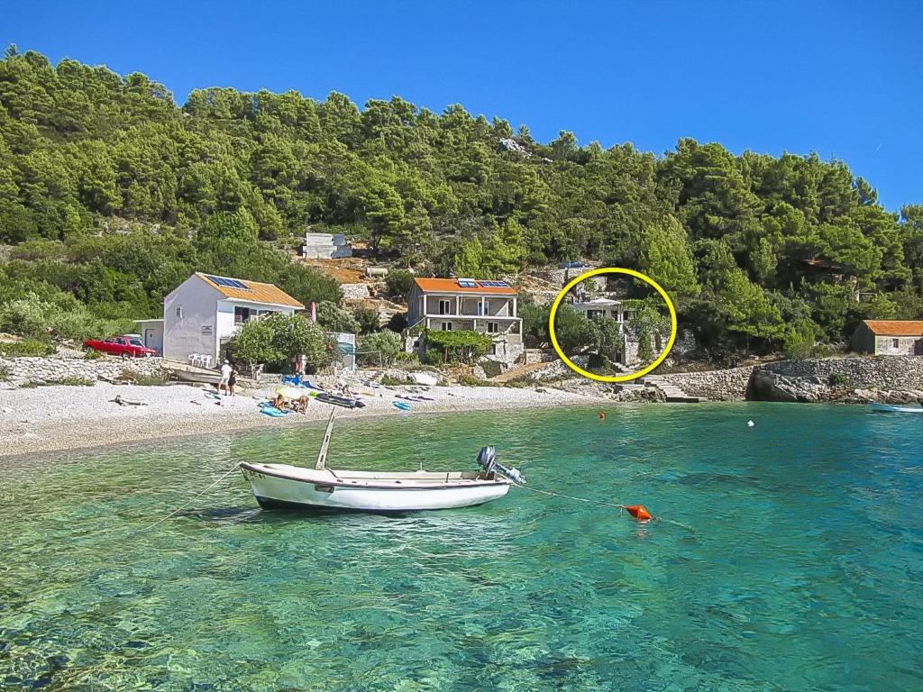 a small boat in the water on a beach at House Herta in Gdinj