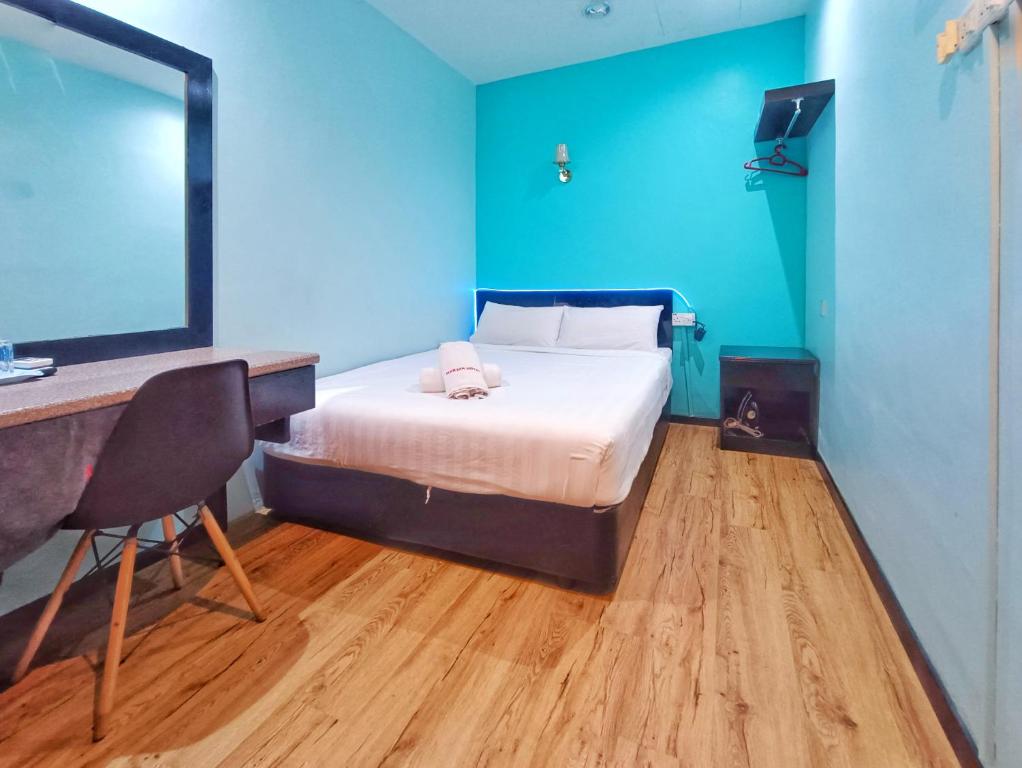 CukaiMarjan Hotel by RVH的一间卧室，配有一张床和一张带电脑的书桌