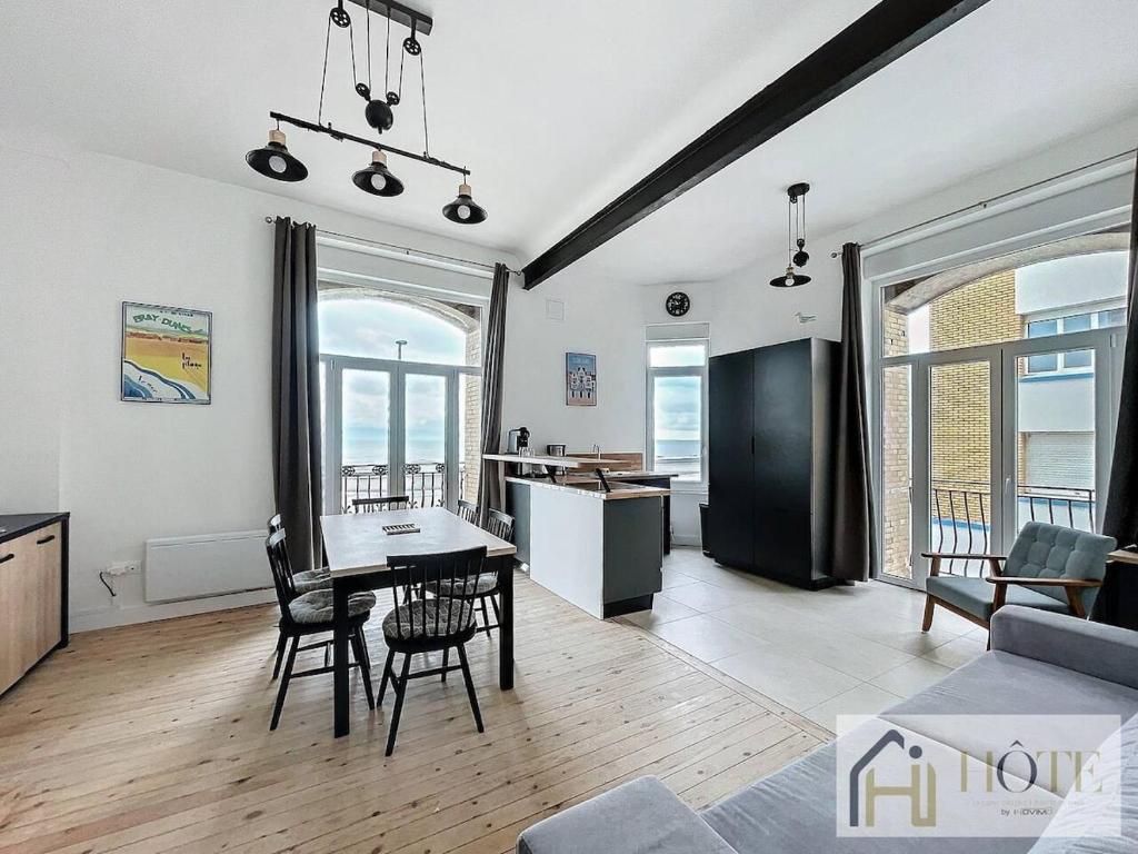 une cuisine et un salon avec une table et des chaises dans l'établissement Elégance Marine - 2 CH Vue Mer, à Bray-Dunes