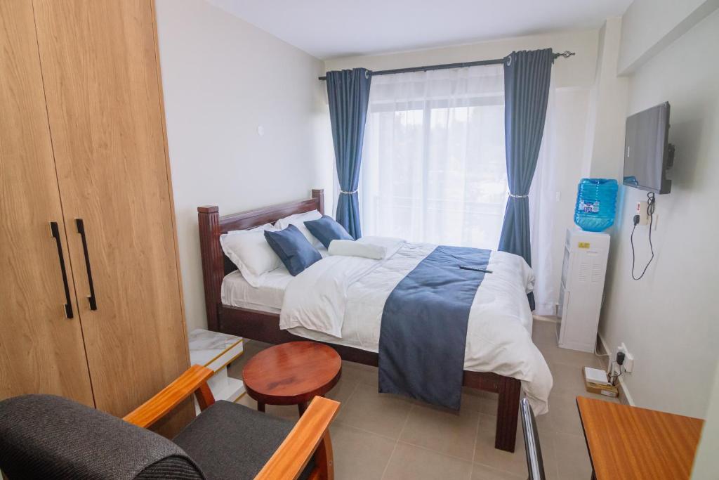 a small bedroom with a bed and a window at Miiza Realtors in Nairobi