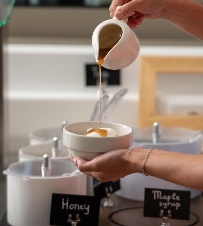 a person is pouring coffee into a bowl at Oniro Boutique Hotel in Toroni