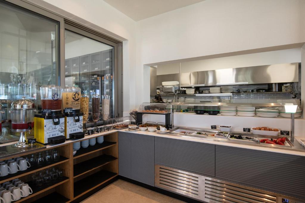 a restaurant kitchen with a counter with a lot of food at Oniro Boutique Hotel in Toroni