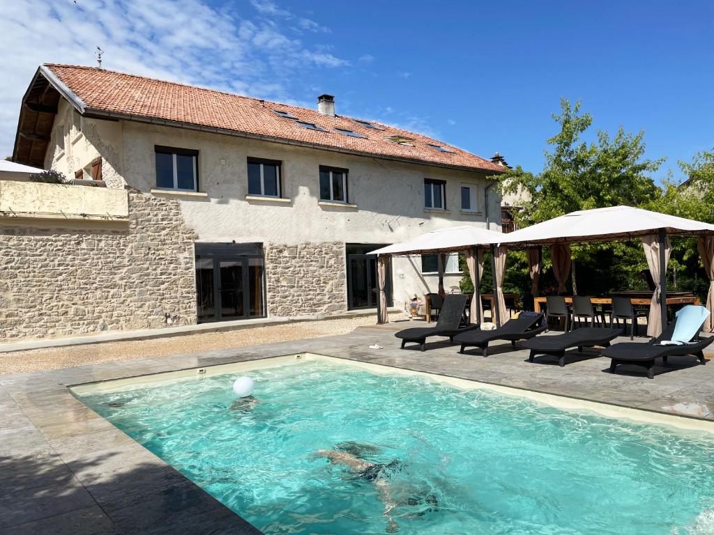 une piscine devant une maison dans l'établissement Gîte 5 chambres piscine vue montagne, à Ordonnaz