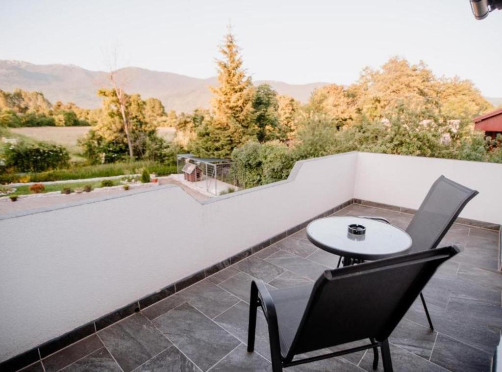 a patio with a table and chairs on a balcony at Mountain Serenity Rooms in Korenica