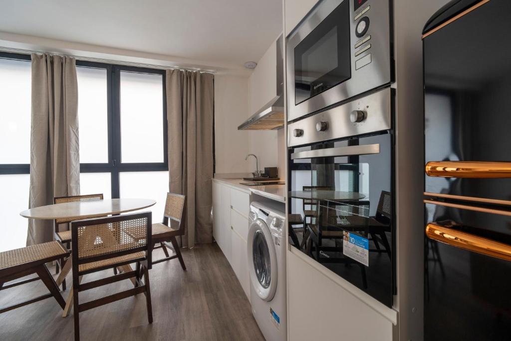 cocina y comedor con lavadora y secadora en VLC Host - Tamarit, en Valencia