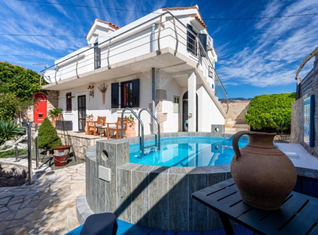 a villa with a swimming pool in front of a house at Rustic Villa Rudine in Dobrinj