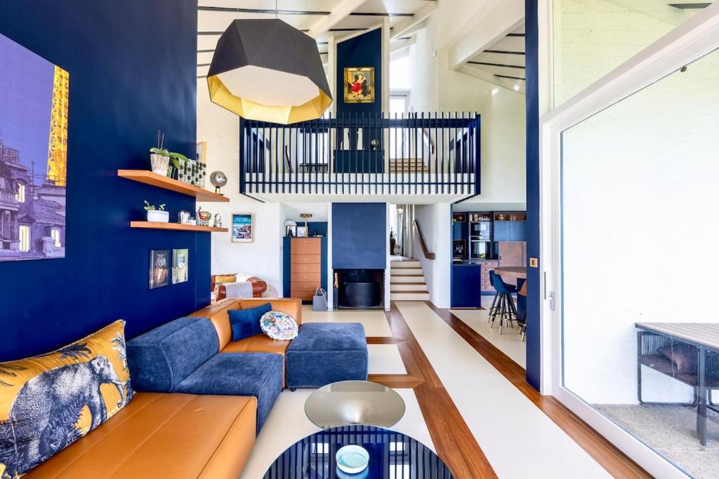 - un salon avec des murs bleus et un canapé bleu dans l'établissement Exclusivité Villa d'Exception en Bord de Mer, à Saint-Cast-le-Guildo