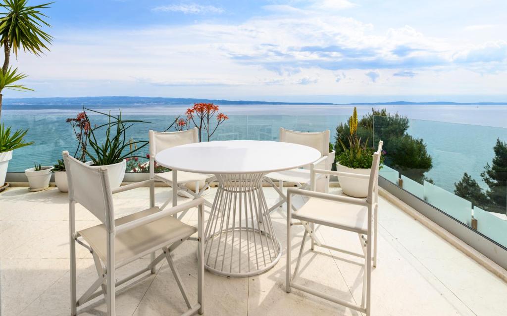 a white table and chairs on a balcony overlooking the water at Gallery Luxury Suites & Rooms-Only Adults in Split