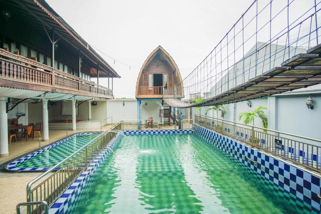 a swimming pool with a slide in a building at Townhouse Oak Ilir Timur I Near Ptc Mall in Palembang