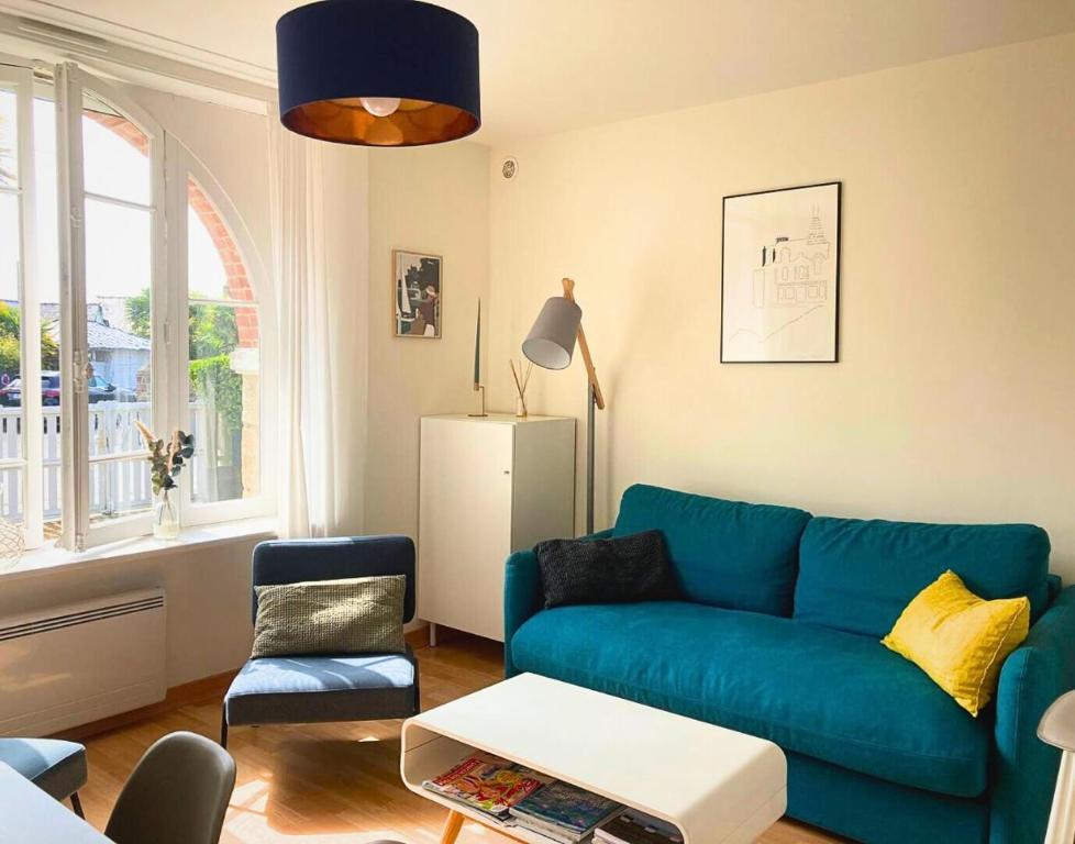 un salon avec un canapé bleu et une chaise dans l'établissement T2 de Charme dans Villa Typique, Proche de la Mer, à Dinard