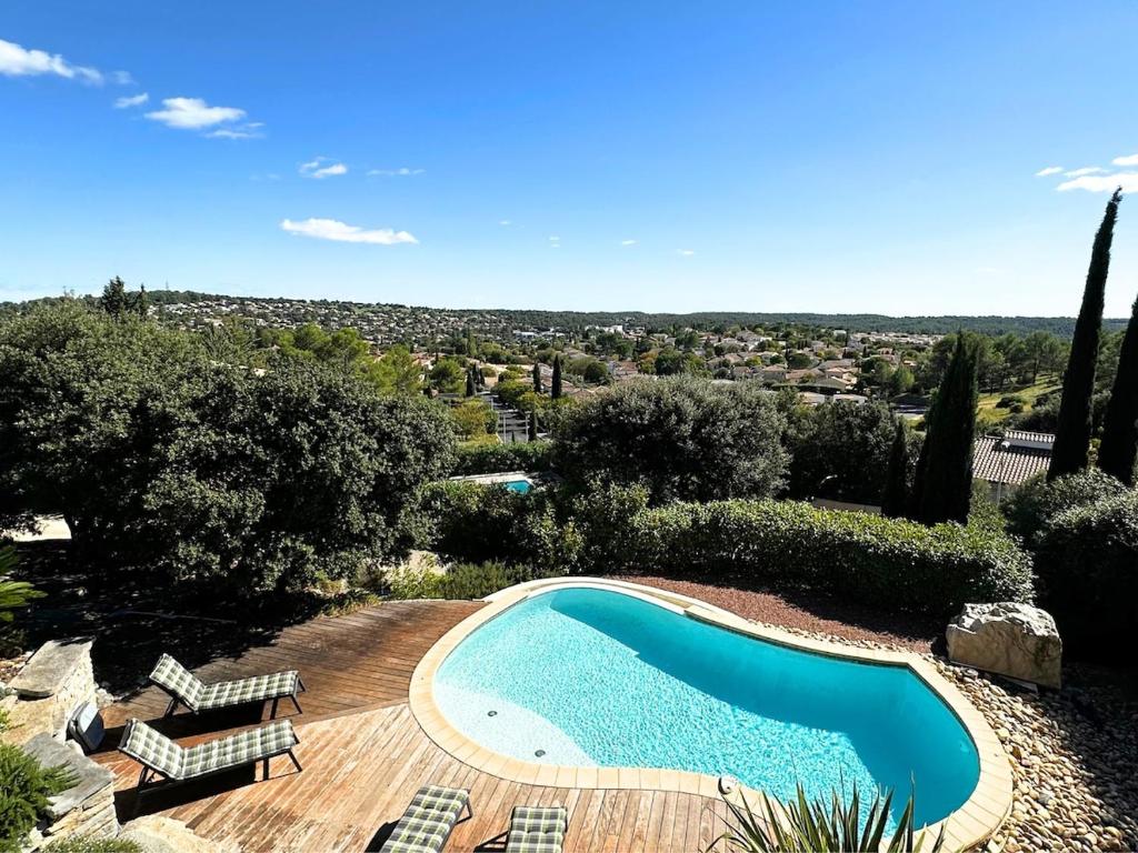 - une piscine sur une terrasse en bois à côté dans l'établissement Villa d'exception avec Piscine et Jardin, à Saint-Gély-du-Fesc