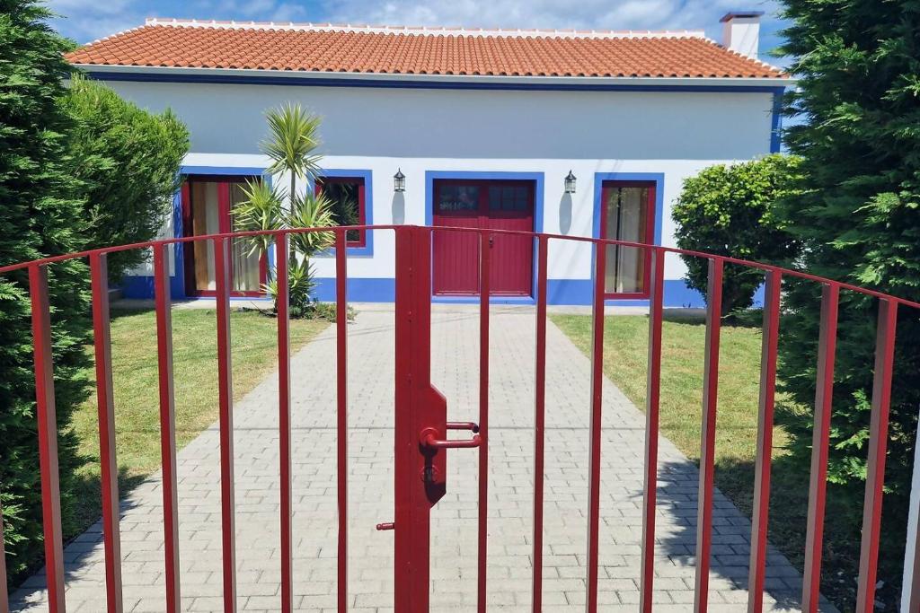 una puerta roja delante de una casa en The North House by Ponta Negra Azores, en Biscoitos