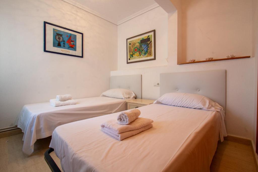 two beds in a room with towels on them at Bungalow en Gran Alacant con Terraza y piscina comunitaria in Puerto Marino