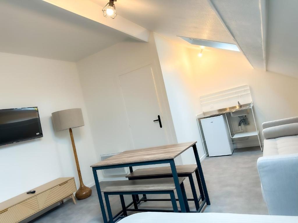 a living room with a table and a couch at Studio B6 - Centre-Ville Meaux - Proche Disneyland in Meaux