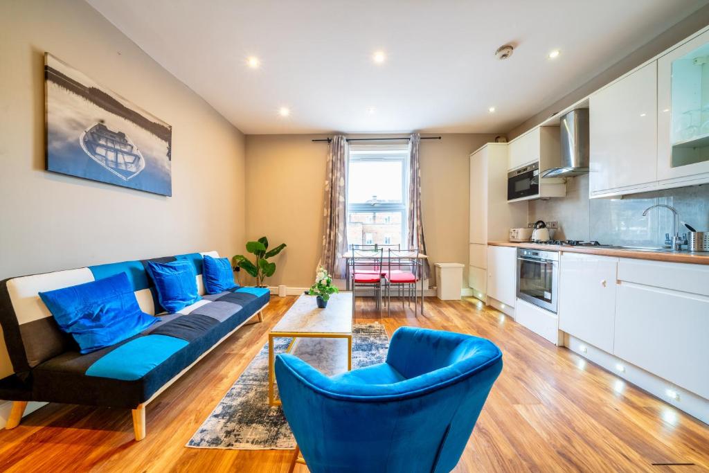 a living room with a couch and blue chairs at Stylish 1BR Prime Location Near Station and Shops in South Norwood