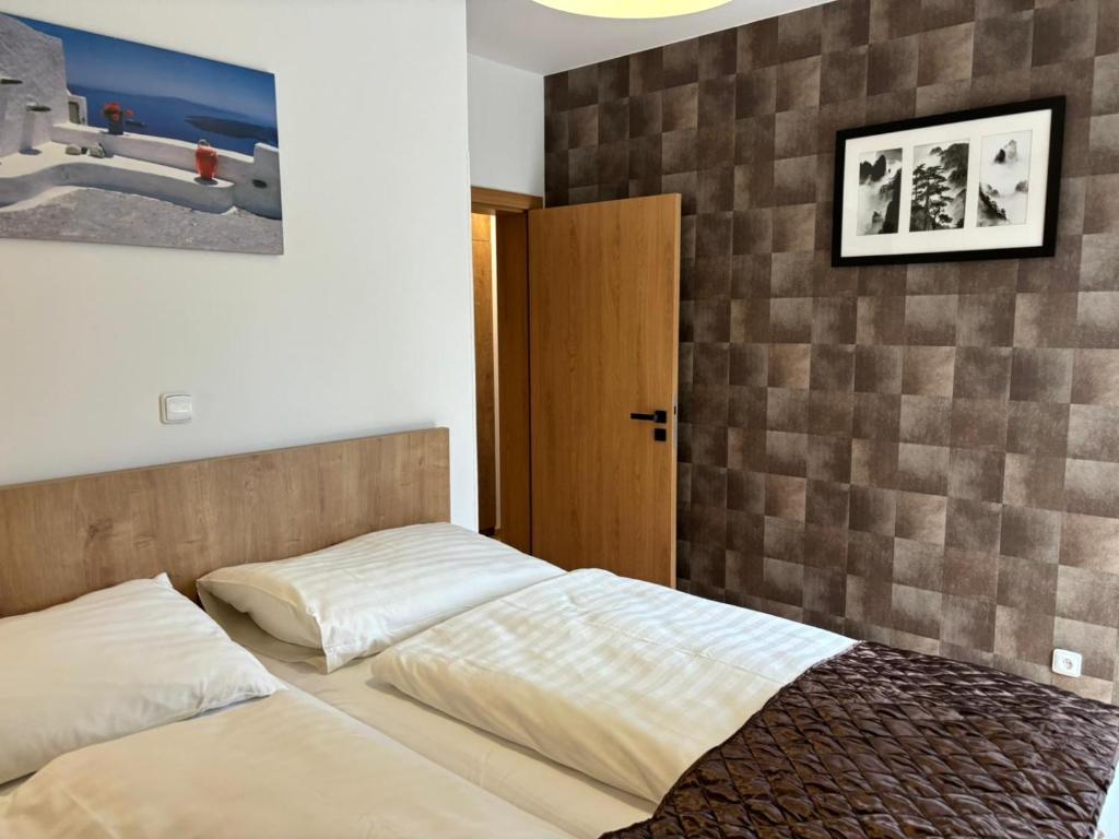 a bedroom with two beds and a wooden door at Premium Resort Skalka in Železná Ruda
