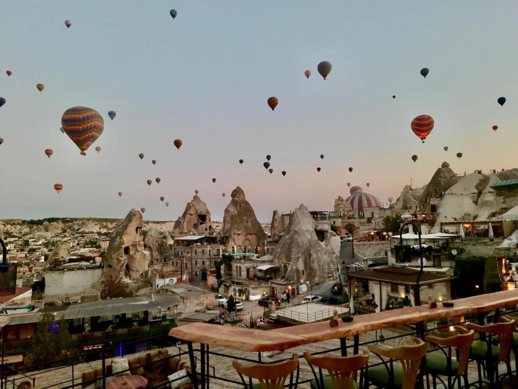 un grupo de globos de aire caliente volando sobre una ciudad en Mia Cappadocia Cave Hotel, en Göreme
