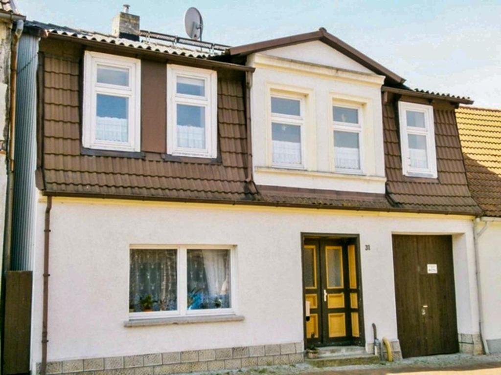 a white house with a brown roof at Ferienwohnung Amelie in Ribnitz-Damgarten