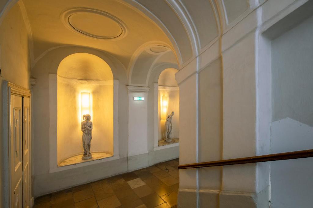 um corredor com duas estátuas num museu em Pertschy Palais Hotel em Viena