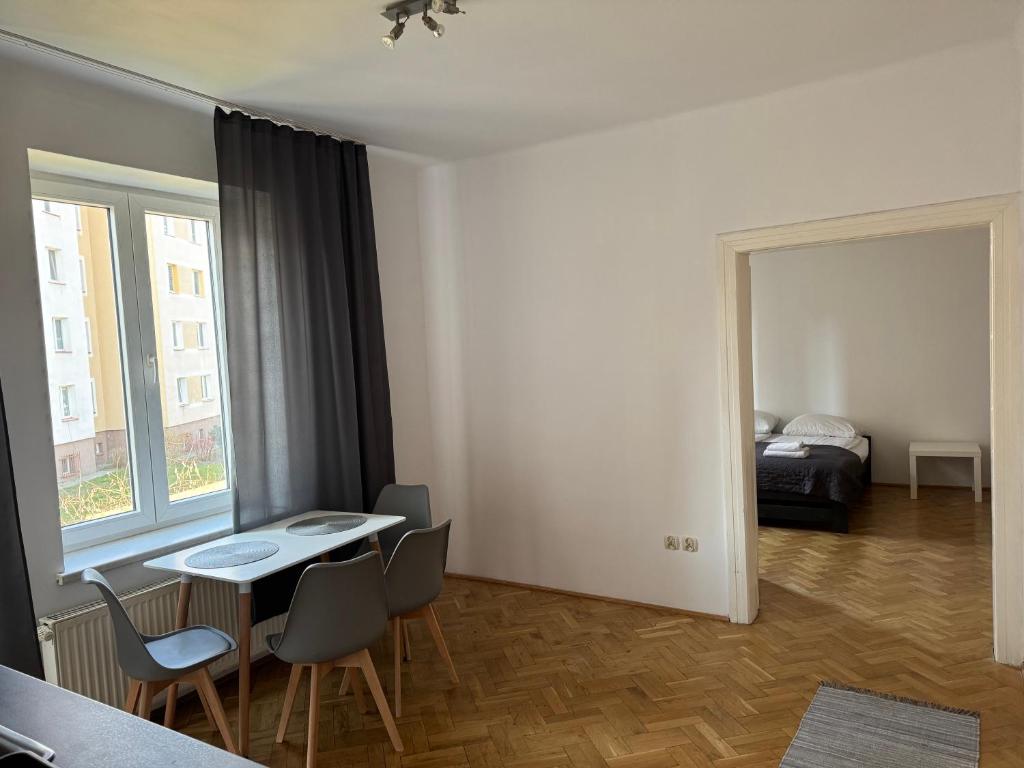 Una habitación con una mesa y sillas y un dormitorio. en Apartamenty 650 metrów od Dworca, en Przemyśl