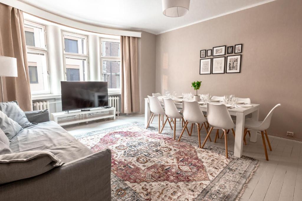 a living room with a dining table and chairs at Spacious 5BR Apartment with Best Location in Kamppi in Helsinki