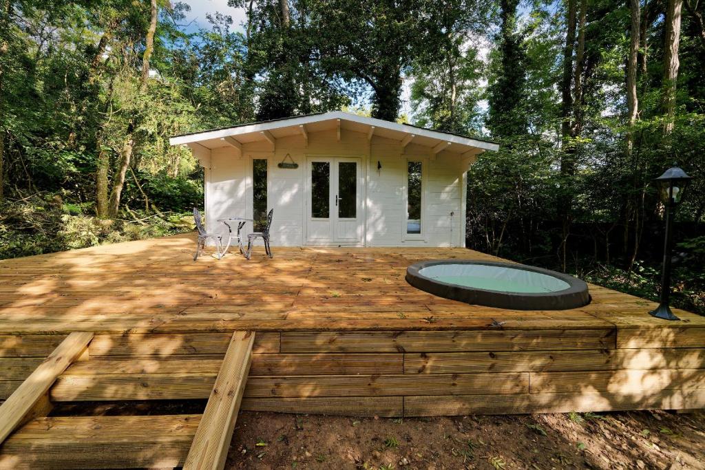 une petite maison avec une piscine sur une terrasse en bois dans l'établissement Le Cottage de St Aubierge, à Mauperthuis