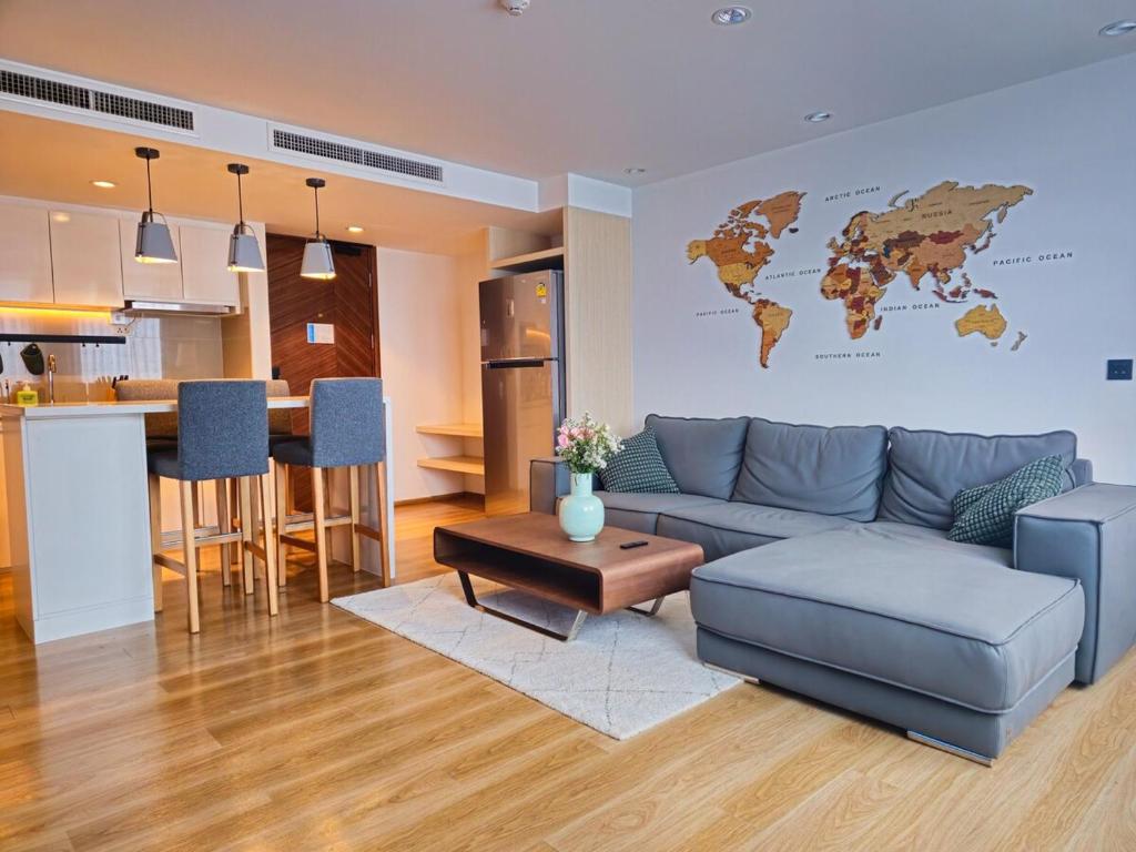 a living room with a blue couch and a world map on the wall at Wonderful View Duplex in La Vita in Rawai Beach