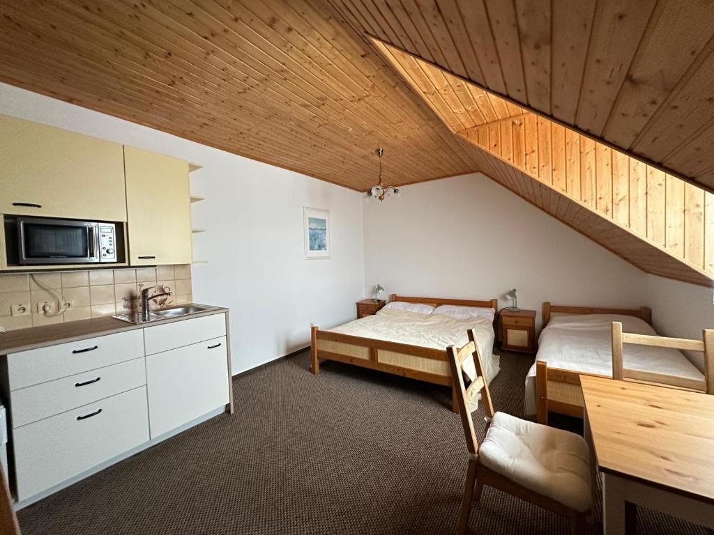 a small room with two beds and a kitchen at Apartmány v Müllerovom dome in Banská Štiavnica