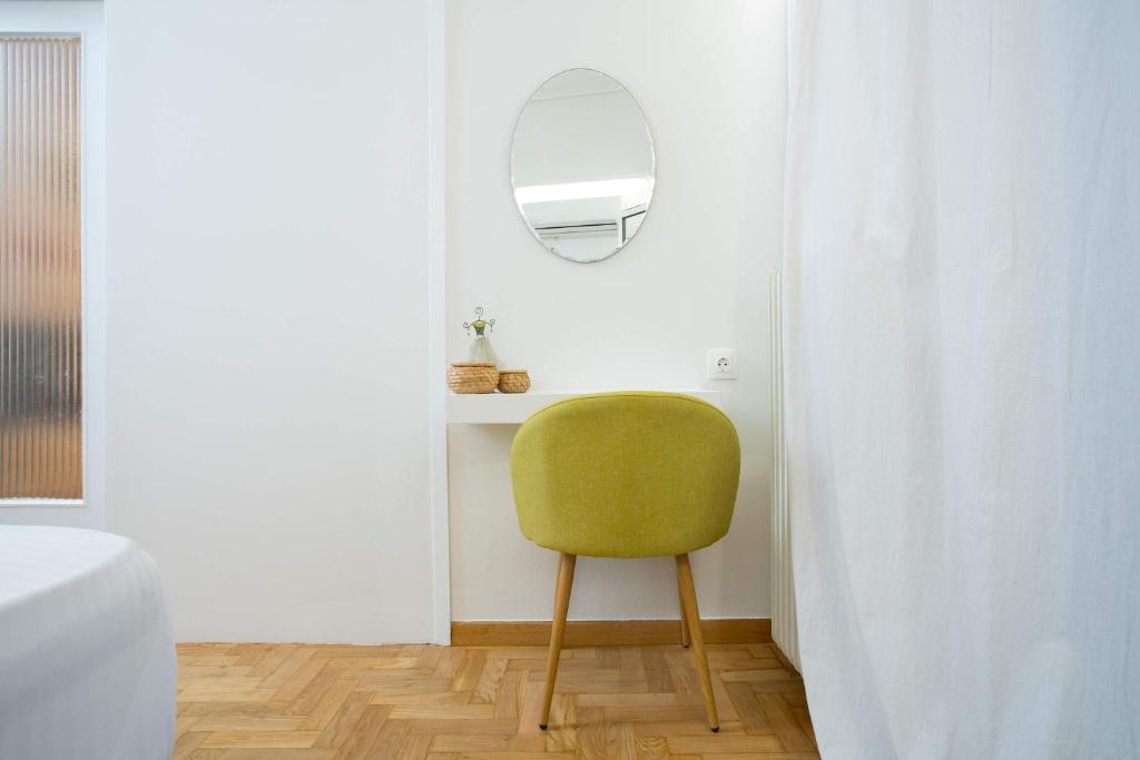 zielone krzesło w pokoju z lustrem w obiekcie O&O Group Ruby's Urban Residence Koukaki w Atenach