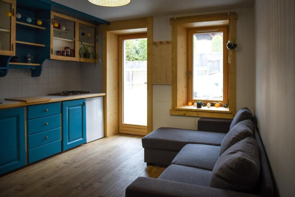 un salon avec un canapé et une cuisine dans l'établissement Au petit Névé, aux Houches