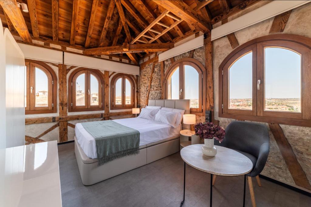 ein Schlafzimmer mit einem Bett in einem Zimmer mit Fenstern in der Unterkunft Apartamentos Santa Fe - Calle Armas by Toledo AP in Toledo