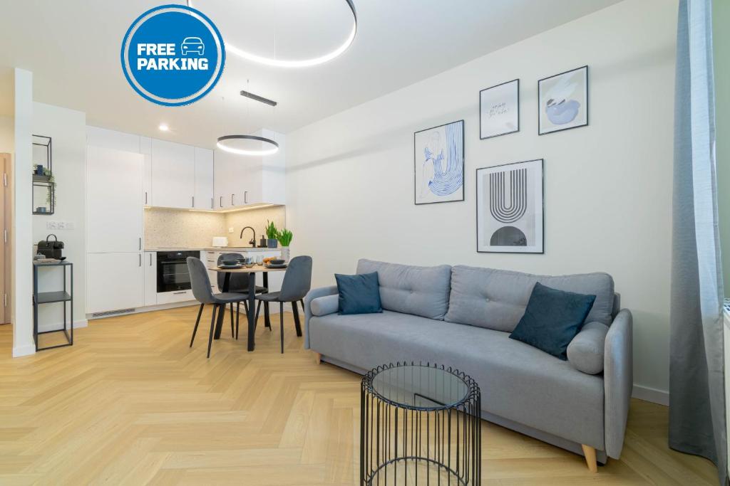 een woonkamer en keuken met een bank en een tafel bij Blue Apartment Ceglana - FREE PARKING - Self check-in in Katowice