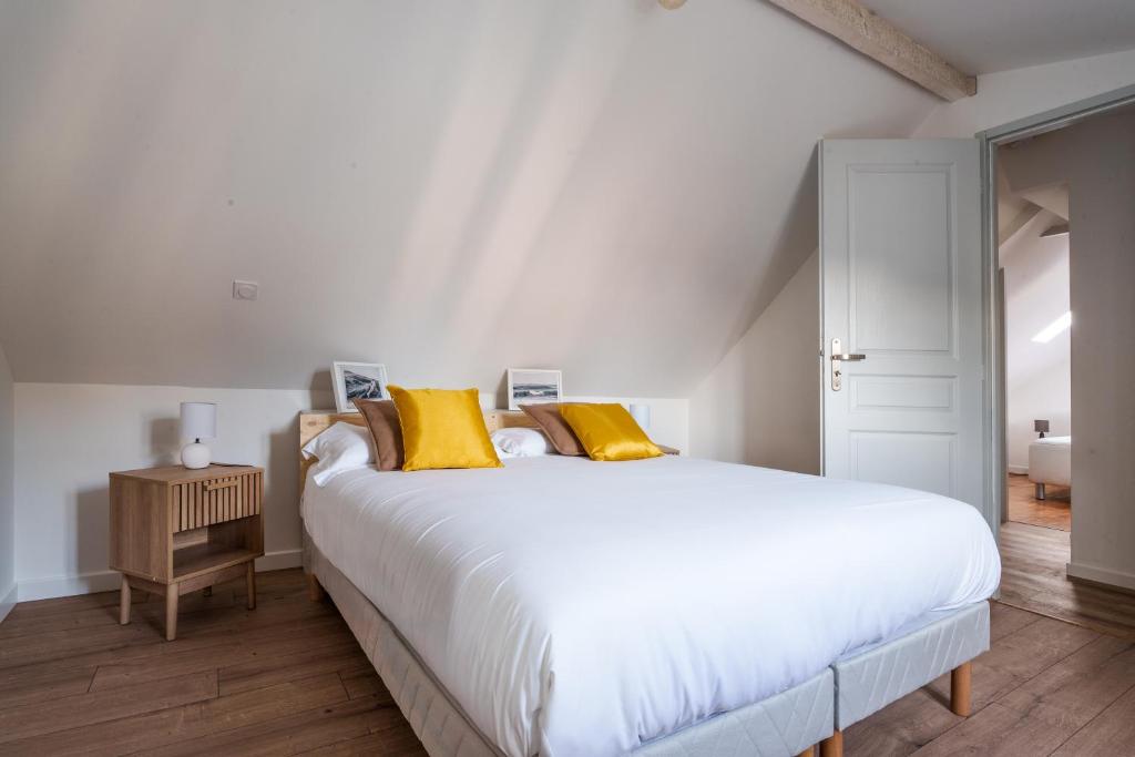 ein Schlafzimmer mit einem großen weißen Bett mit gelben Kissen in der Unterkunft Maison clim jardin Tours centre 8 personnes 4 chambres in Tours